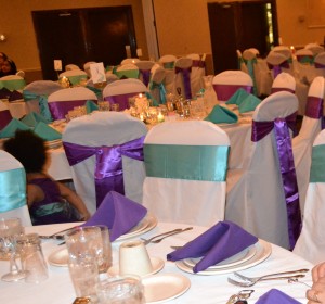 Banquet chair covers with turquoise and purple sashes